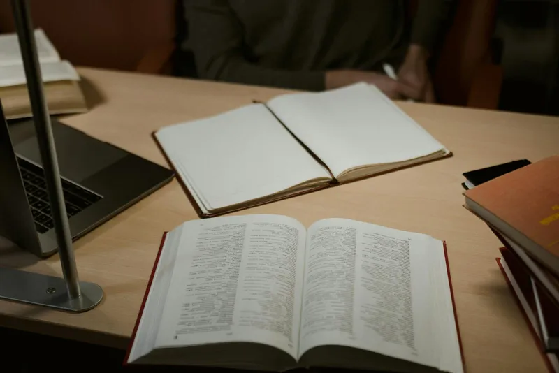 Open notebook and books arranged on a wooden desk